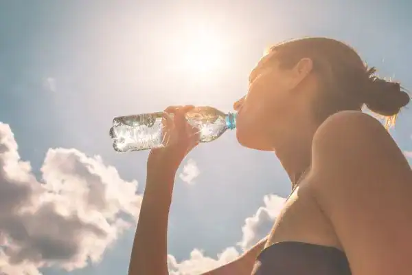 Hydration: The Secret Ingredient for a Toned Stomach and Enhanced Fitness 3 Image of woman drinking water to hydrate Bradford after run.